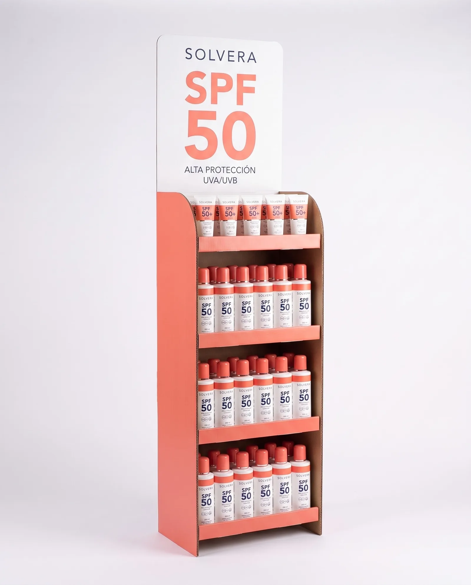 Narrow Solvera cardboard floor display with four shelves of sunscreen, coral sides and a white header with SPF 50