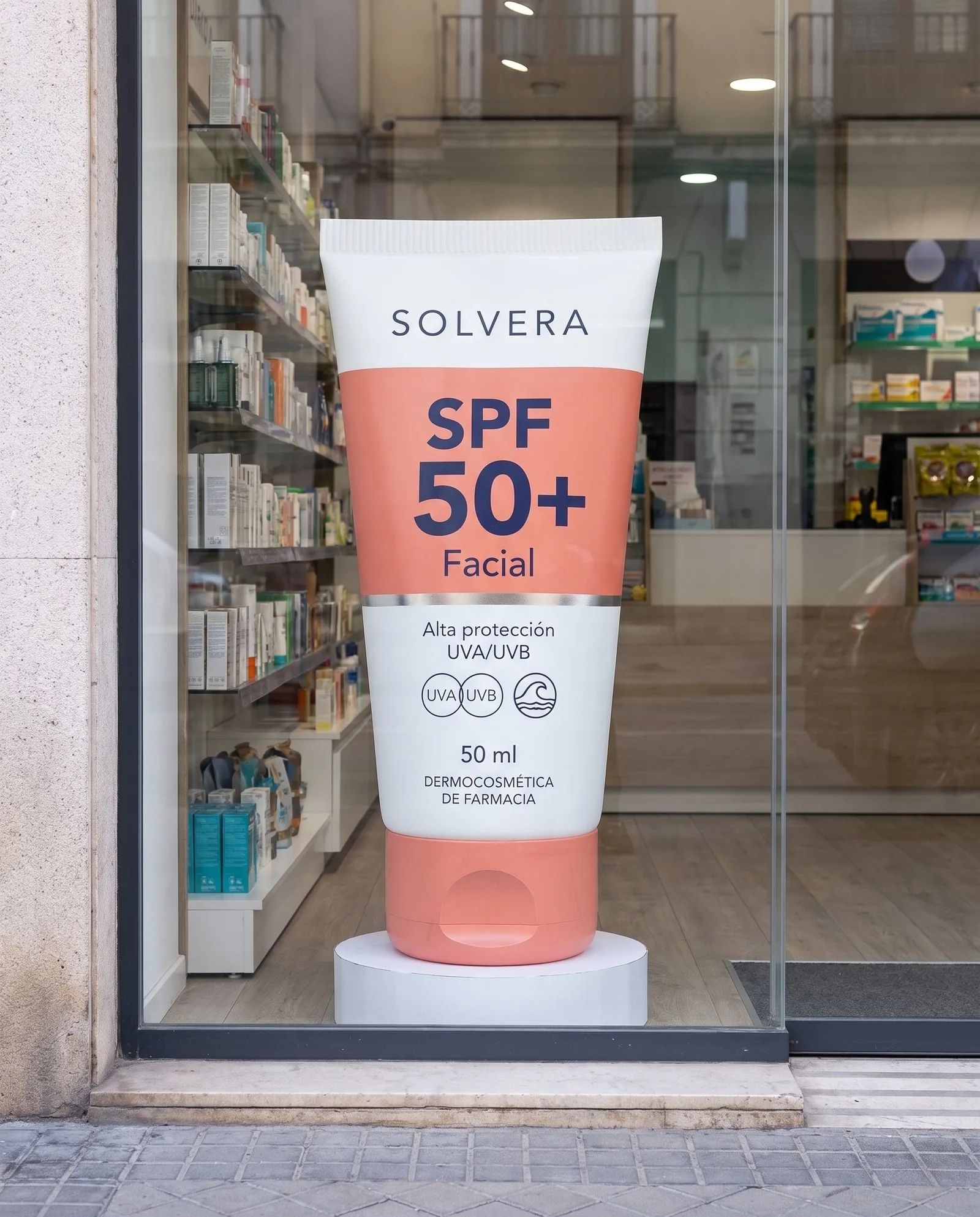 El mismo ficticio de suelo de Solvera en el escaparate de una farmacia, visto desde la acera