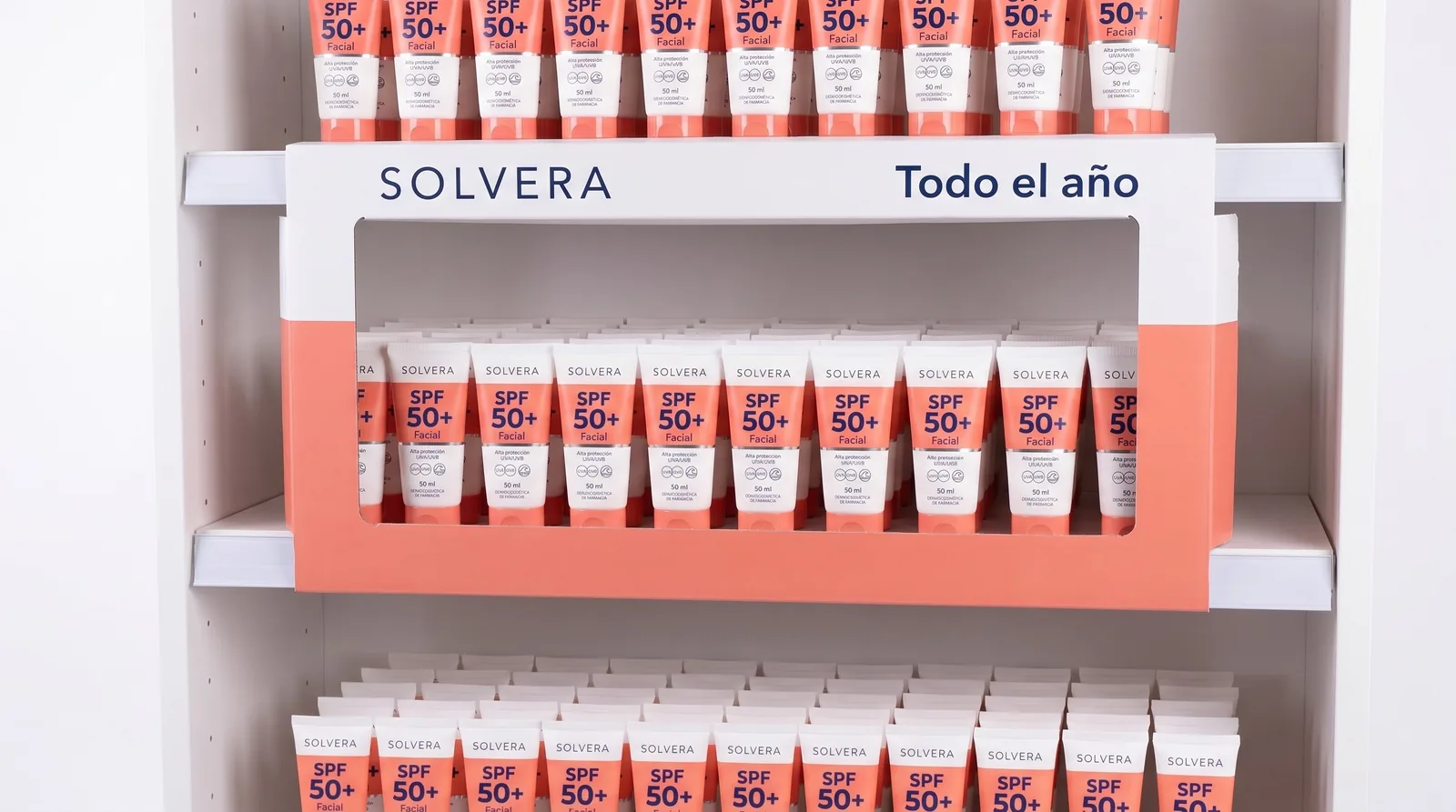 Marco de lineal blanco y coral de Solvera con el logo y el texto Todo el año alrededor de una balda de tubos de protector solar facial
